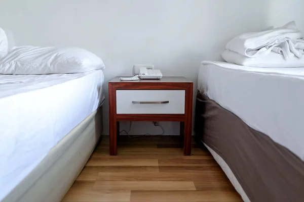 ベッドサイドテーブルと電話2台のベッドの間のホテル — ストック写真