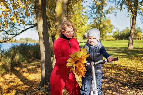 Matka Podzimním Parku Učí Svého Syna Jezdit Kole Koncept Výchovy — Stock fotografie