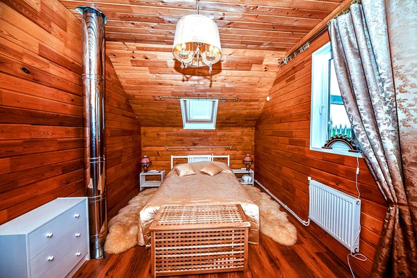 Interior of the bedroom in a wooden village house is made of birch timber-clapboard