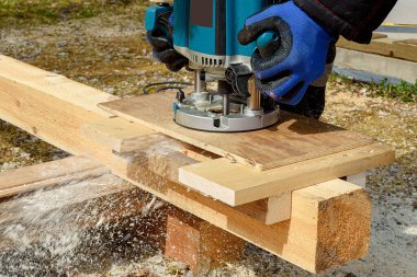 Yuvarlak bir makinede odun öğütme işlemi. Tahta oyma tutkusu. Profesyonel erkeklerin elleri..