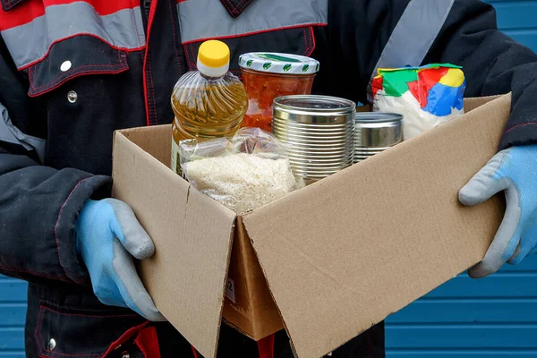 Kışlık Ceketli Bir Gönüllü Içinde Kuru Tahıllar Konserve Yiyecekler Tereyağı — Stok fotoğraf