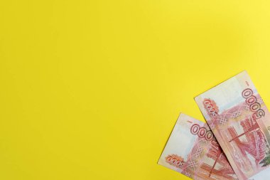 5000 rublelik banknotlar. Sarı arka planda izole edilmiş Rus para birimi banknotları. Yukarıdan yakından bak. Maaş, tasarruflar