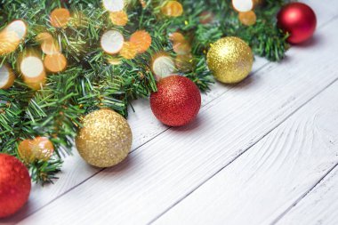 Noel kompozisyonu köknar dalları, altın ve kırmızı balonlar beyaz ahşap arka planda