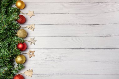 Noel kompozisyonu köknar dalları, altın ve kırmızı balonlar, tahta oyuncaklar beyaz ahşap arka planda