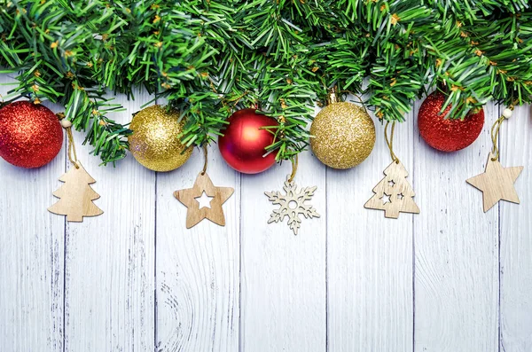 モミの枝 黄金と赤の風船 白い木製の背景に木製のおもちゃでクリスマスの組成物 — ストック写真