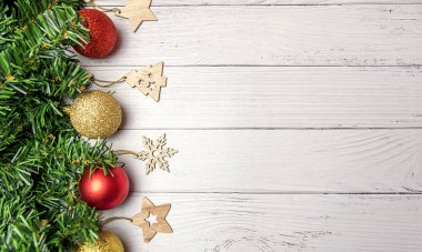 Noel kompozisyonu köknar dalları, altın ve kırmızı balonlar, tahta oyuncaklar beyaz ahşap arka planda