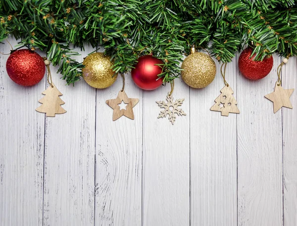モミの枝 黄金と赤の風船 白い木製の背景に木製のおもちゃでクリスマスの組成物 — ストック写真