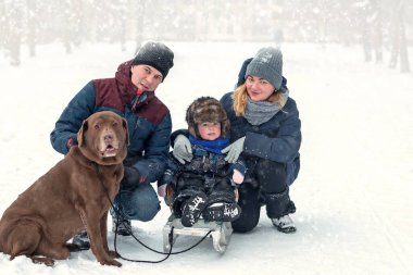 Bir oğlan ve Labrador köpeği olan genç bir aile yürüyüş yaparken eğleniyor. Seçici Odaklanma