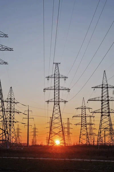 日の出と空を背景にした高電圧電気塔のシルエット 送電線 — ストック写真