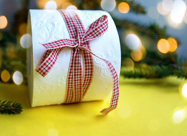 Toilettenpapierrolle Als Weihnachtsgeschenk Neben Weihnachtsbaum Und Weihnachtsbeleuchtung Auf Gelbem Hintergrund — Stockfoto