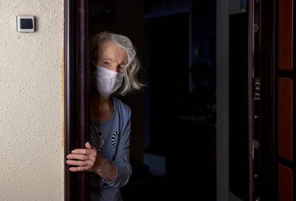 Una Donna Anziana Con Una Maschera Guarda Fuori Mentre Aspetta — Foto Stock