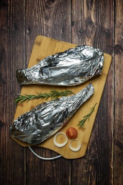 Taze dorado balığı. Dorado ve ahşap bir masada yemek pişirmek için malzemeler.