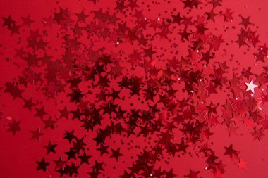 Kırmızı arkaplanda yıldız şeklinde kırmızı konfeti.