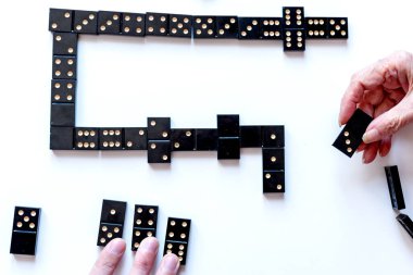 Eğlenceli bir domino oyunu için aile eğlencesi. Torun ve büyükanne domino oynuyorlar. Yukarıdan görünüşü.