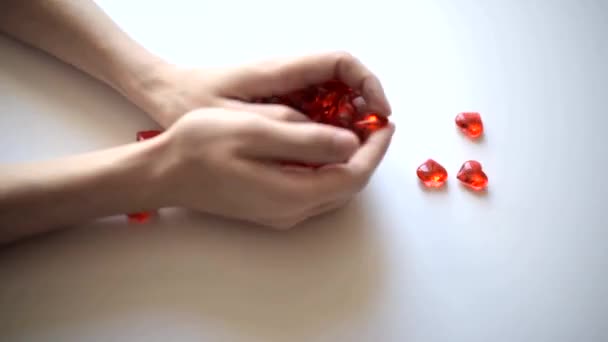 Руки Молодого Человека Бросают Стол Красные Камни Форме Сердца — стоковое видео