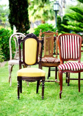 Açık hava düğün etkinlikleri için çeşitli yapılandırmalarda tasarımcı ahşap sandalyeler..