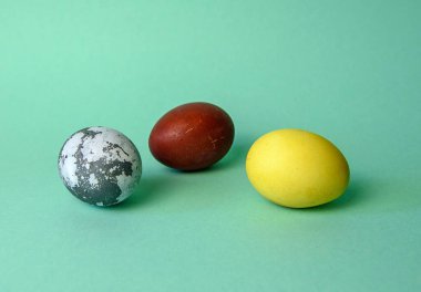 Yeşil neon arka planda doğal boyayla boyanmış üç yumurta. Asgari bayram ya Paskalya ya da yemek konseptidir. Soyut yumurta boyama konsepti. Minimalizm eğilimi