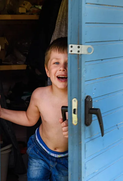 Пятилетний Мальчик Закрывает Дверь Дом Смеясь — стоковое фото