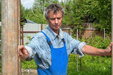 Adam doğada gerçek bir inşaat alanında inşaatçı. Bir evin inşası