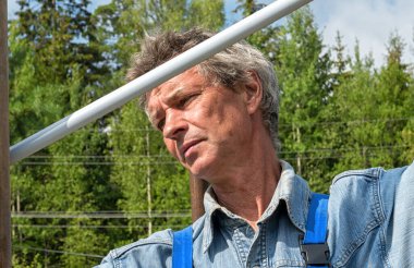 Doğada gerçek bir inşaat alanında mezurası olan bir erkek müteahhit. Bir mezura ile iletiler arasındaki mesafeyi ölçer