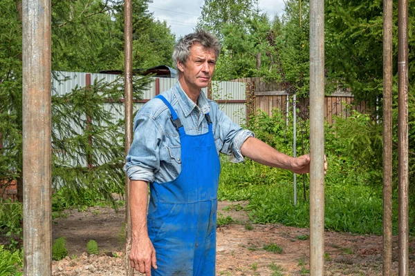 Adam doğada gerçek bir inşaat alanında inşaatçı. Bir evin inşası