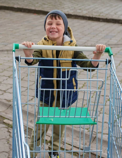 Kid Boy Duwen Leeg Winkelwagentje Parkeerplaats — Stockfoto