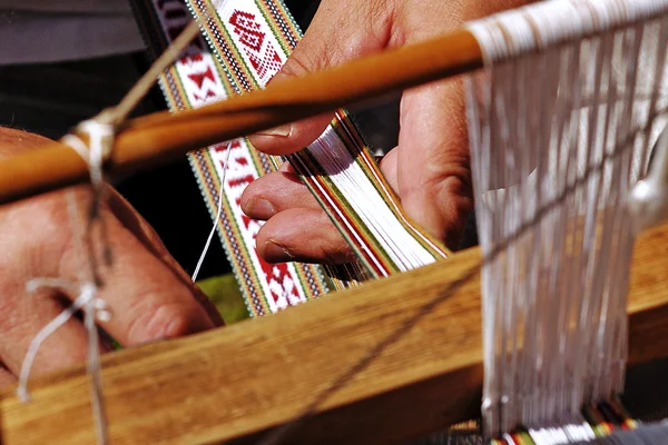 Men hands at the loom.