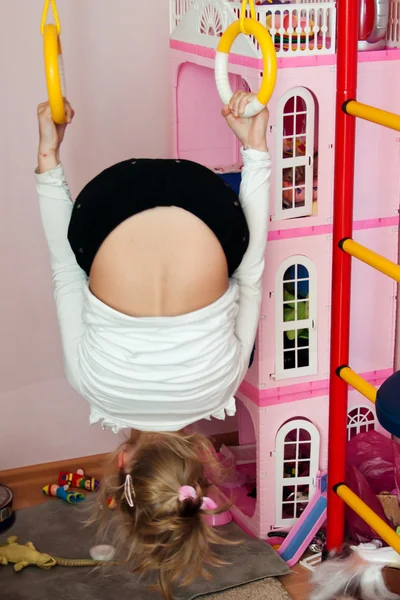 Child hanging upside down on the rings — Stock Photo, Image