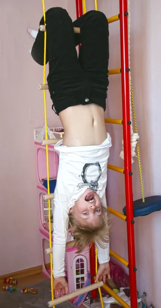 Child hanging upside down on the rings — Stock Photo, Image