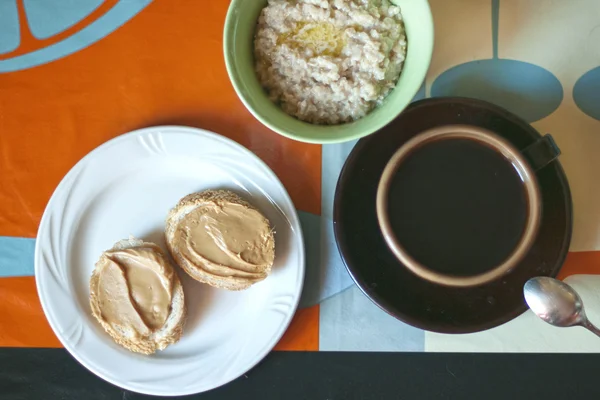 Śniadanie - płatki owsiane, kanapki z masłem orzechowym i kawy — Zdjęcie stockowe