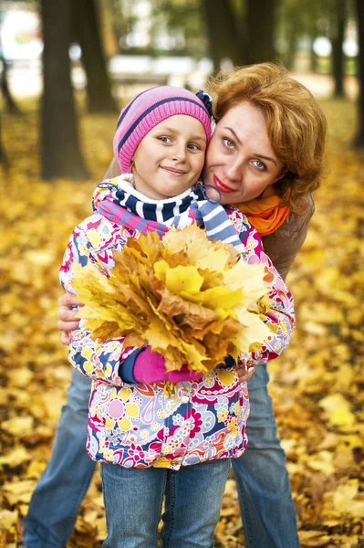 Jeune femme avec une fille dans le parc d'automne — Photo