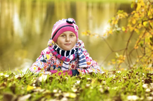 Dívka ležela na trávě v podzimním parku — Stock fotografie