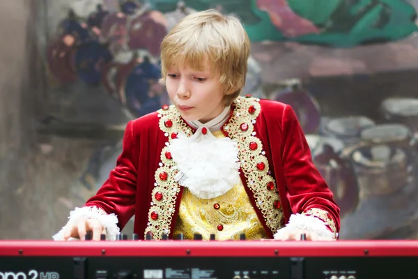 Menino em traje período tocando o teclado — Fotografia de Stock