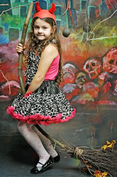 Beautiful little girl in the red cap with horns on Halloween — Stock Photo, Image