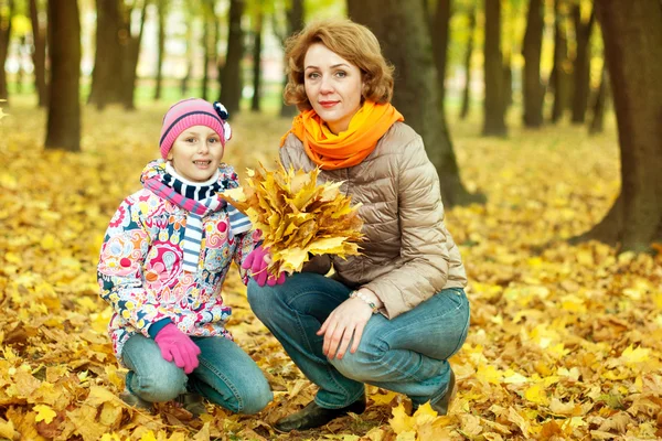 Dívka si hraje se svou matkou v podzimním parku — Stock fotografie