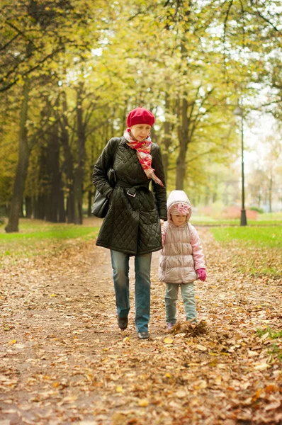 Maman et fille marchent dans le parc d'automne — Photo