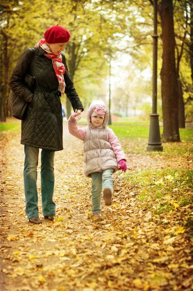 Máma a dcera chodí v podzimním parku — Stock fotografie
