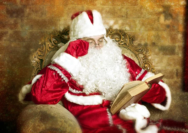 Der Weihnachtsmann liest ein Buch — Stockfoto