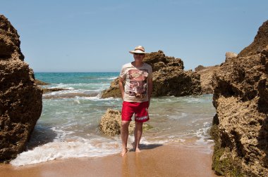 Okyanusta hasır şapkalı mutlu adam