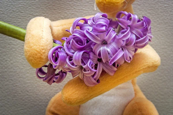 Conejo de juguete de composición de Pascua sosteniendo una flor — Foto de Stock