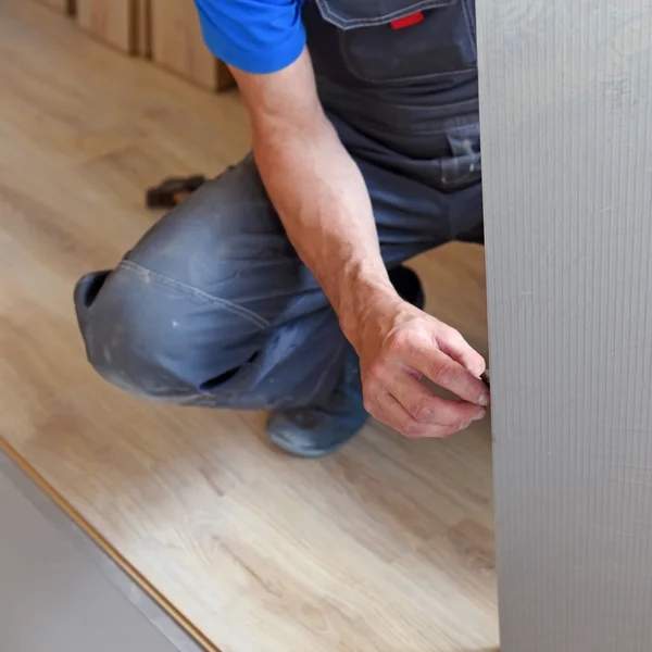 Male carpenter selects a substrate for laminate — Stock Photo, Image