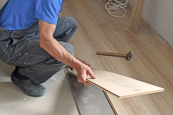 Carpinteiro masculino coloca o laminado — Fotografia de Stock