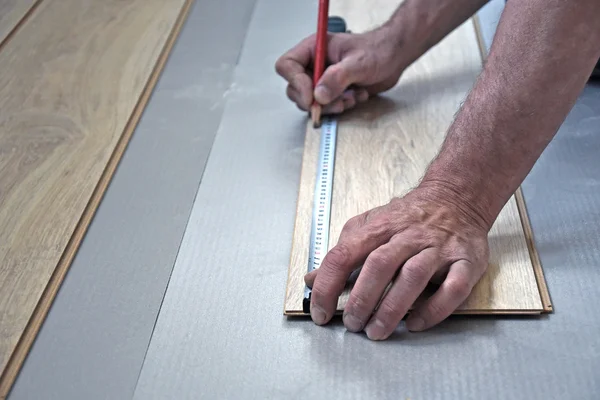Carpinteiro masculino coloca o laminado — Fotografia de Stock