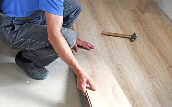 Male carpenter puts the laminate — Stock Photo, Image