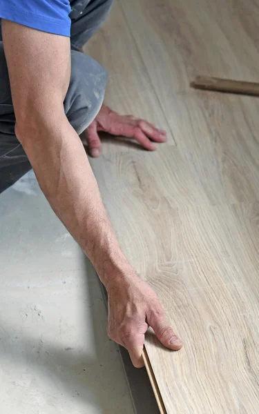 Male carpenter puts the laminate — Stock Photo, Image