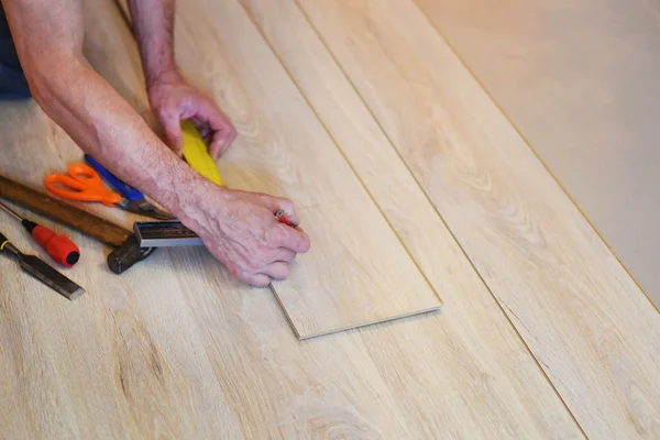 Hands of a carpenter mark on the Board — Stock Photo, Image