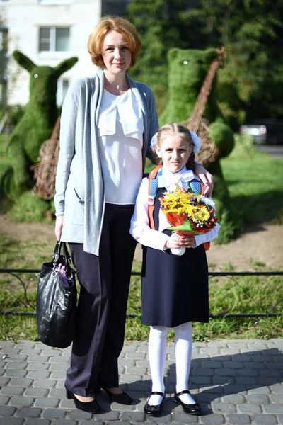 Mère et fille ensemble le jour avec des fleurs . — Photo