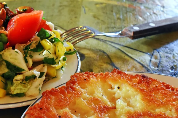 Salat und Pfannkuchen auf einem Holztisch — Stockfoto