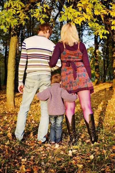 Fils étreint les pieds de maman et papa dans le parc d'automne — Photo