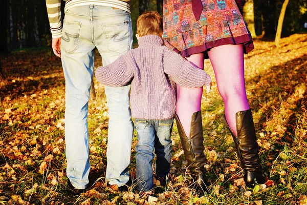 Fils étreint les pieds de maman et papa dans le parc d'automne — Photo